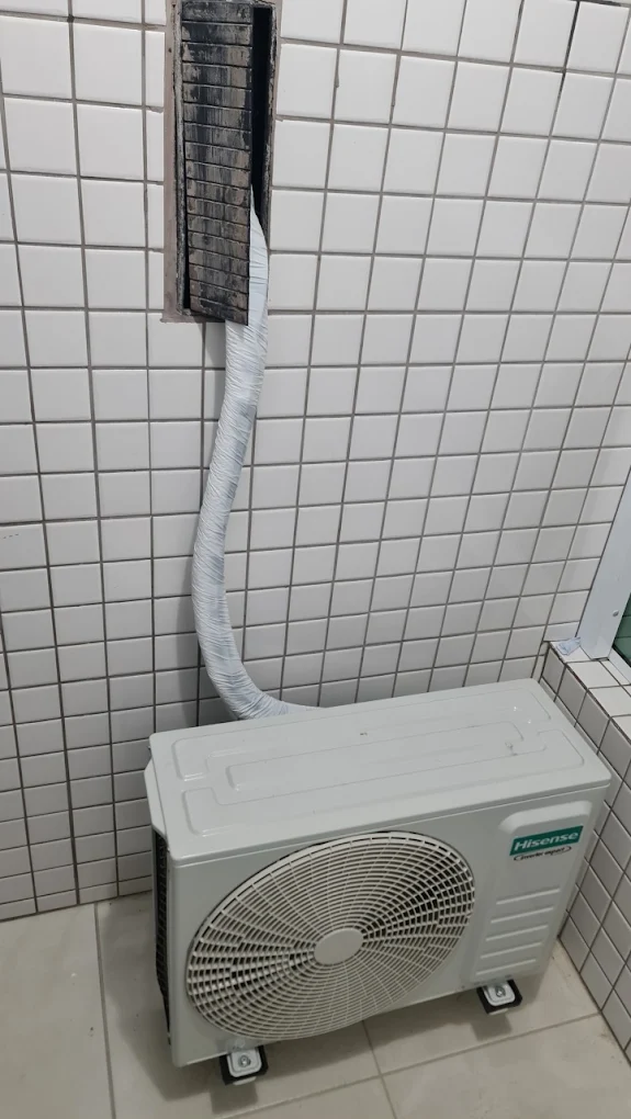 Condensadora instalada no piso da varanda com tubulação embutida em canaleta